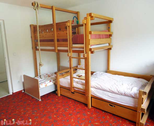 Bei diesem Etagenbett-seitlich-versetzt ist die Leiter so positioniert, dass unter die obere Schlafebene noch weitere Kindermöbel passen, hier z.B. ein zusätzliches kleines Bett.
